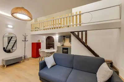a living room with a blue couch and a staircase at Trastevere Experience in Rome