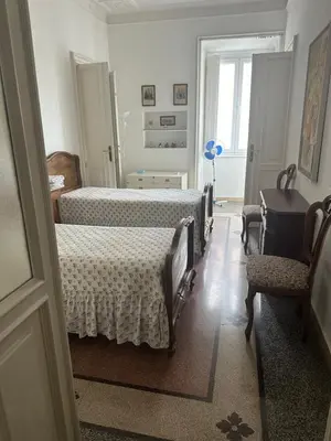 a bedroom with two beds and a table and a chair at Nel cuore di Roma in Rome