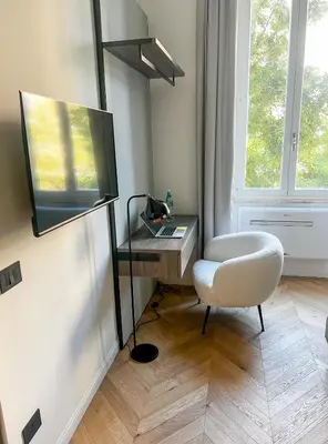 a room with a chair and a desk and a television at Vatican Boutique - 2 bedroom apartment - Trilocale in Rome