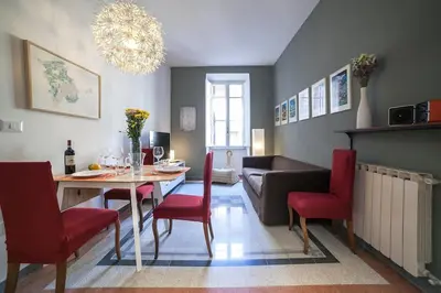 a living room with a table and red chairs at Monti 3 bedroom apartment Colisseum in Rome