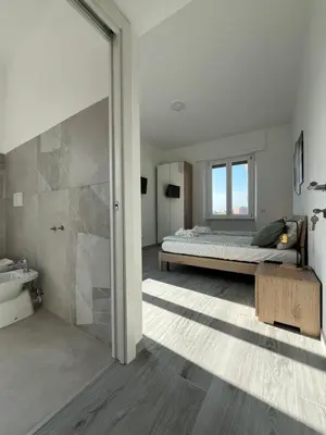 a bedroom with a bed and a shower and a sink at Paolettas House in Rome