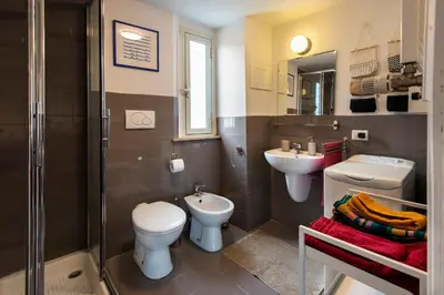 a kitchen with white cabinets and a wooden floor at Attichetto Monteverde in Rome