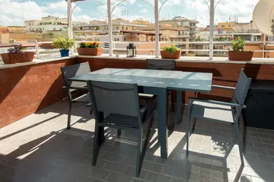 a table and chairs on the roof of a building at Attichetto Monteverde in Rome