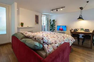 a bedroom with a bed with a floral bedspread and a balcony at Attichetto Monteverde in Rome
