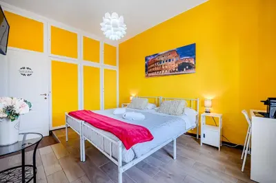 a bedroom with yellow walls and a bed at Domus Antica Trastevere in Rome