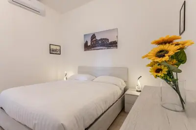 a bedroom with a bed and a vase with sunflowers at A Casa di Max - Battistini Station 
