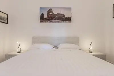 a bedroom with a large white bed with two lamps at A Casa di Max - Battistini Station 
