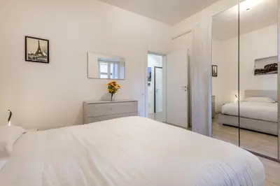 a white bedroom with a bed and a mirror at A Casa di Max - Battistini Station 