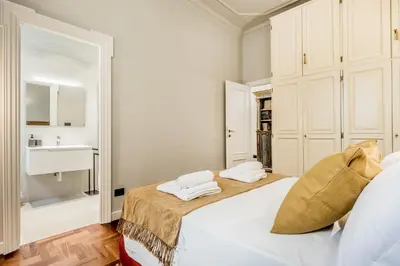 a white bedroom with two beds and a sink at BBHOME Eleganza e comfort unico in San Giovanni district in Rome