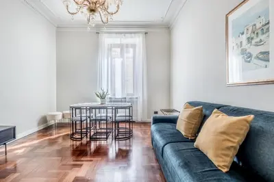 a living room with a blue couch and a table at BBHOME Eleganza e comfort unico in San Giovanni district in Rome