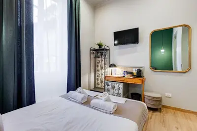 a bedroom with a bed with a mirror and a tv at Vivilo Collection - Charme 24 Suites - Close to Via Veneto in Rome