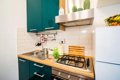 a kitchen with green cabinets and a stove top oven at La casina sull'appia in Rome
