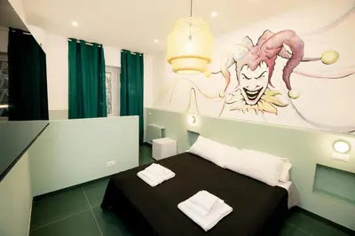 a room with a bed with a painting on the wall at O Effe Games Vatican in Rome
