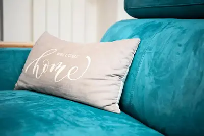 a blue couch with a pillow that says welcome home at Romina in Rome
