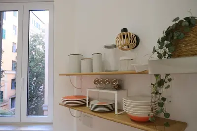 a kitchen with shelves with dishes and a window at Casa Frida Arte e Sport tra MAXXI e Olimpico in Rome