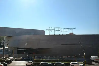 a large building with cars parked in a parking lot at Casa Frida Arte e Sport tra MAXXI e Olimpico in Rome