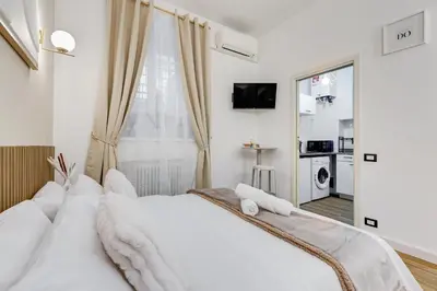 a bedroom with a large white bed with white pillows at Vicolo Sereno Roma in Rome