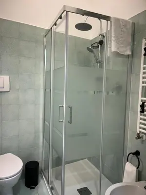 a glass shower in a bathroom with a toilet at La Casita in Rome