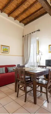 a living room with a table and a red couch at Piazza Navona Apartment in Rome