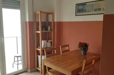 a dining room with a wooden table and a book shelf at Casa Marconi apt in Rome