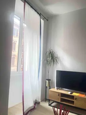 a living room with a tv and a window at Testaccio sul Tevere romantic historical close FAO in Rome