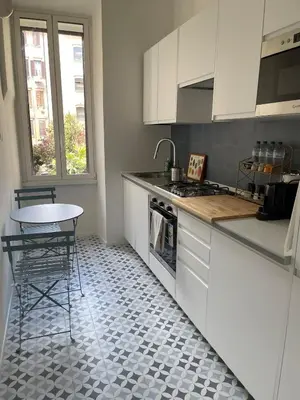 a kitchen with white cabinets and a table and a stove at Testaccio sul Tevere romantic historical close FAO in Rome