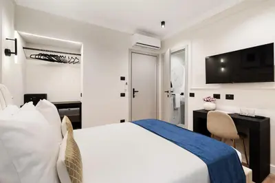 a bedroom with a bed and a desk and a television at Piave Boutique Guest House in Rome