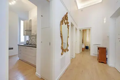 a large white hallway with a mirror on the wall at Binario 30 in Rome
