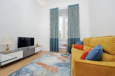a living room with a yellow couch and a tv at Binario 30 in Rome