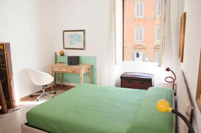 a bedroom with a green bed and a desk and a window at Shangrila in Rome