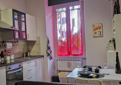 a kitchen with two red windows and a table at Appartamento JazzNBlues House in Rome