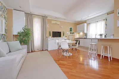 a living room with a couch and a table and a kitchen at Lucky Domus Tuscolano in Rome