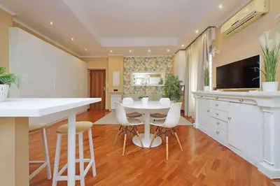 a kitchen with a white table and white chairs at Lucky Domus Tuscolano in Rome