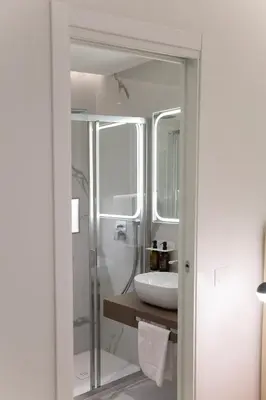 a white bathroom with a sink and a shower at 56 Orange Street Luxury Accommodation in Rome