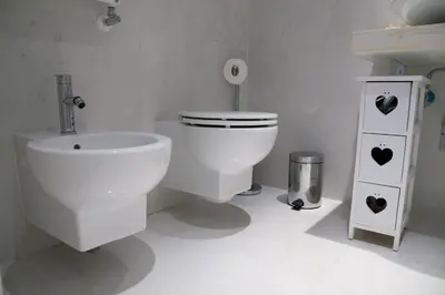 a white bathroom with a toilet and a sink at Big Johnny B in Rome