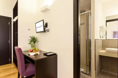 a bathroom with a desk and a purple chair at Domus Best Guest House in Rome