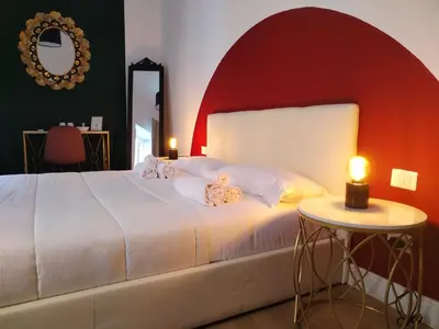 a bedroom with a white bed with a red wall at Enotri Guest House - Rome in Rome