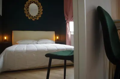 a bedroom with a bed with a chair and a mirror at Enotri Guest House - Rome in Rome