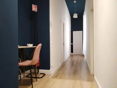 a hallway with blue walls and a table and chairs at Enotri Guest House - Rome in Rome