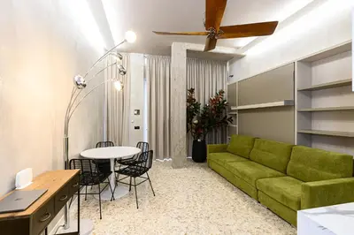 a bedroom with a white bed with a tv on the wall at New Modern in Trastevere with Garden in Rome