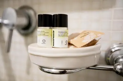 two bottles of moisturizers sitting on a holder in a bathroom at Elegant apartment in Trastevere in Rome