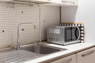 a microwave sitting on a kitchen counter next to a sink at Elegant apartment in Trastevere in Rome