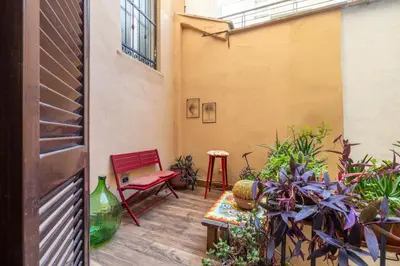 a patio with a red chair and some plants at Cesare Balbo - B&D Apts in Rome