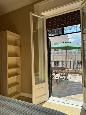 an open door to a patio with an umbrella at Elegante appartamento con terrazzo in Rome