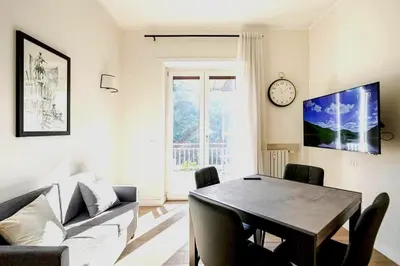 a living room with a table and a couch and a clock at Roma Essence Vaticano e Comfort in Rome