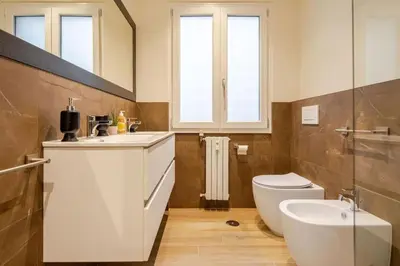 a bathroom with a toilet and a sink and a mirror at Roma Essence Vaticano e Comfort in Rome