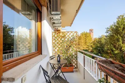 a balcony with a table and chairs and a window at Roma Essence Vaticano e Comfort in Rome