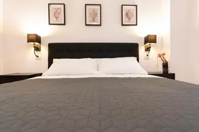 a bedroom with a large bed with three pictures on the wall at Residenza Lucrezio in Rome