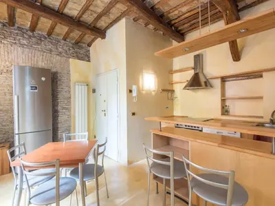a kitchen and dining room with a wooden table and chairs at Charming Luxury Trastevere Apartment in Rome