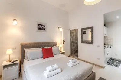 a bedroom with a bed with a red pillow on it at Loft in the Ghetto in Rome